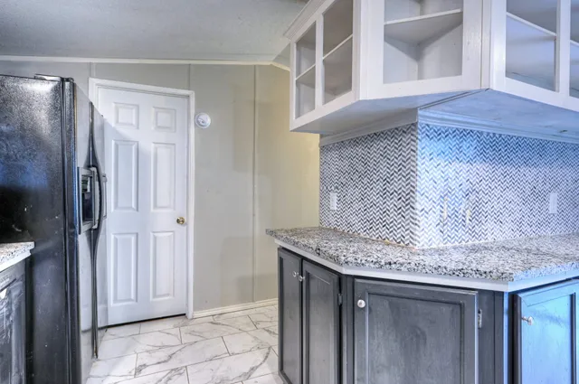 a kitchen with stainless steel appliances granite countertop a refrigerator and a sink