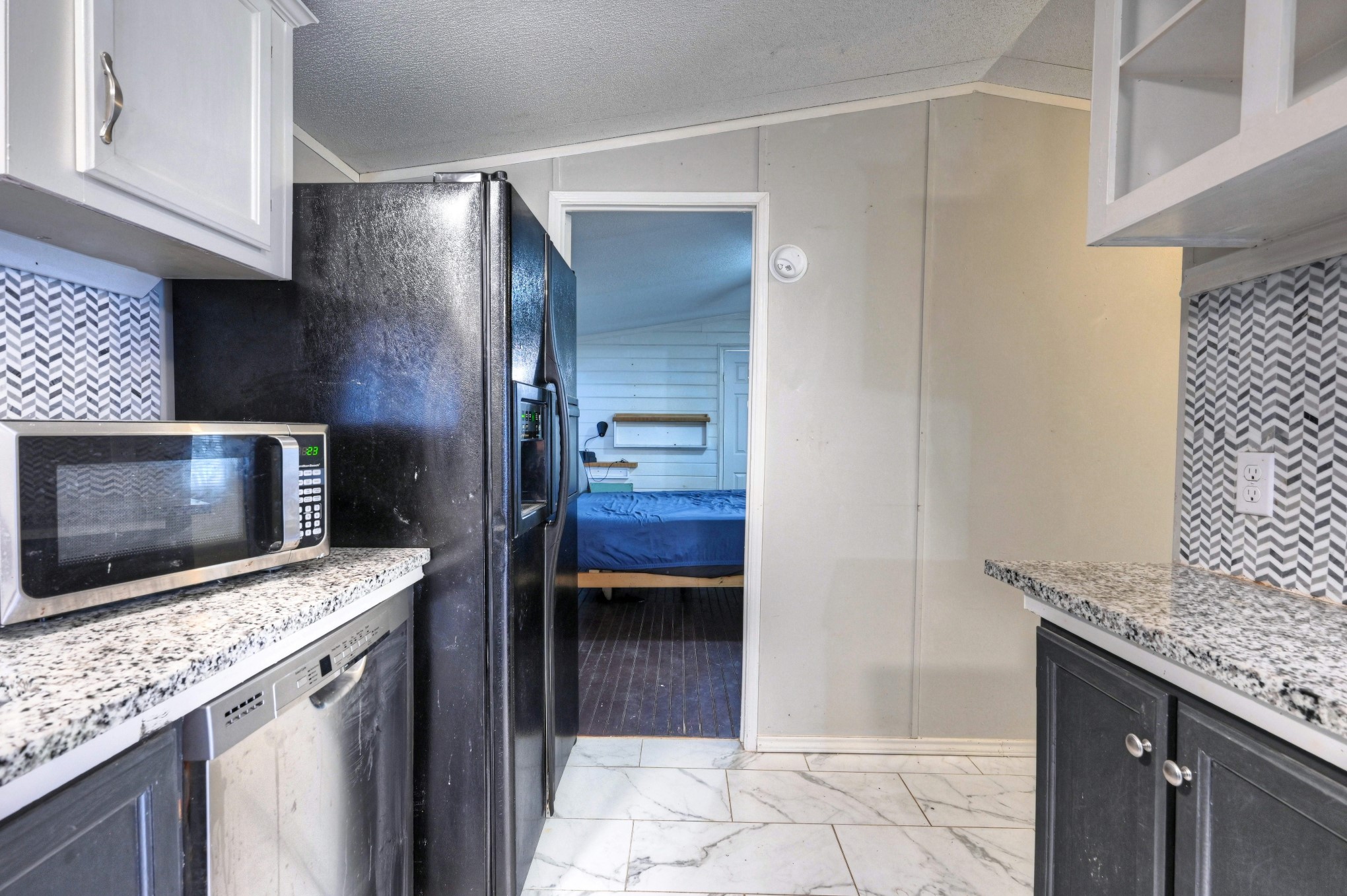 13204 Enchanted Vista Willis, TX 77318 - Photo 23 of 43 a kitchen with stainless steel appliances kitchen island granite countertop a stove a microwave and a sink