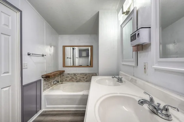 a bathroom with a tub sink and mirror