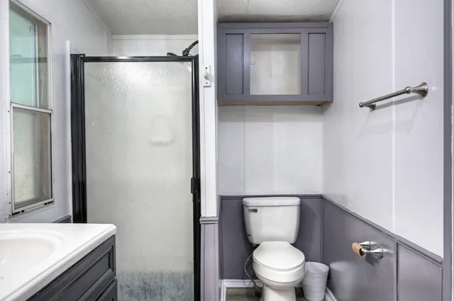 a bathroom with a granite countertop sink toilet and shower