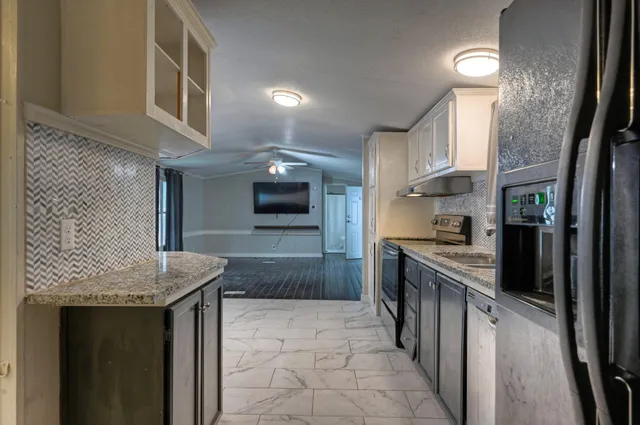 a kitchen with stainless steel appliances granite countertop a stove a sink and a refrigerator