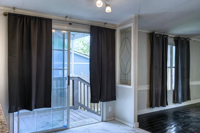 a view of a hallway with wooden floor and staircase
