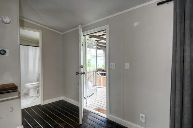 a view of a room that has a bed and wooden floor