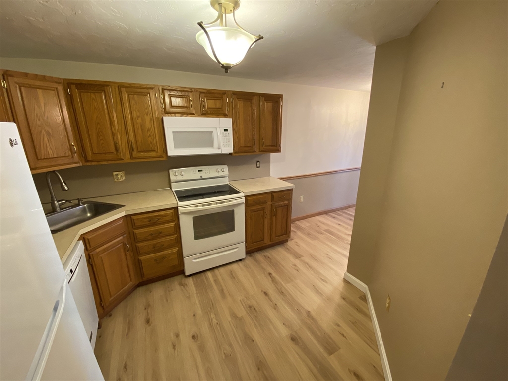 501 Ridgefield Circle, Unit B Clinton, MA 01510 - Photo 5 of 17 a kitchen with stainless steel appliances a stove a sink and a refrigerator