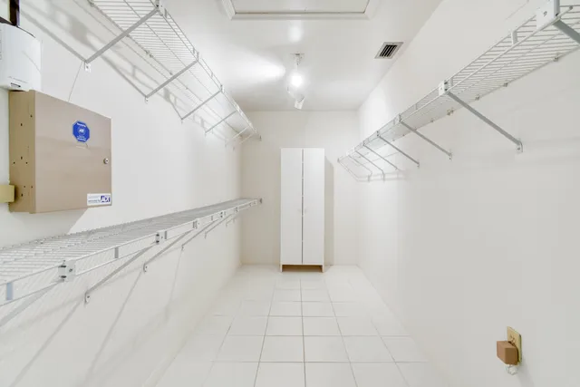 a view of a brick building with many windows and a yard