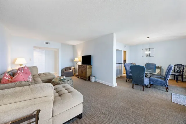 a dining room with furniture a large window and a chandelier