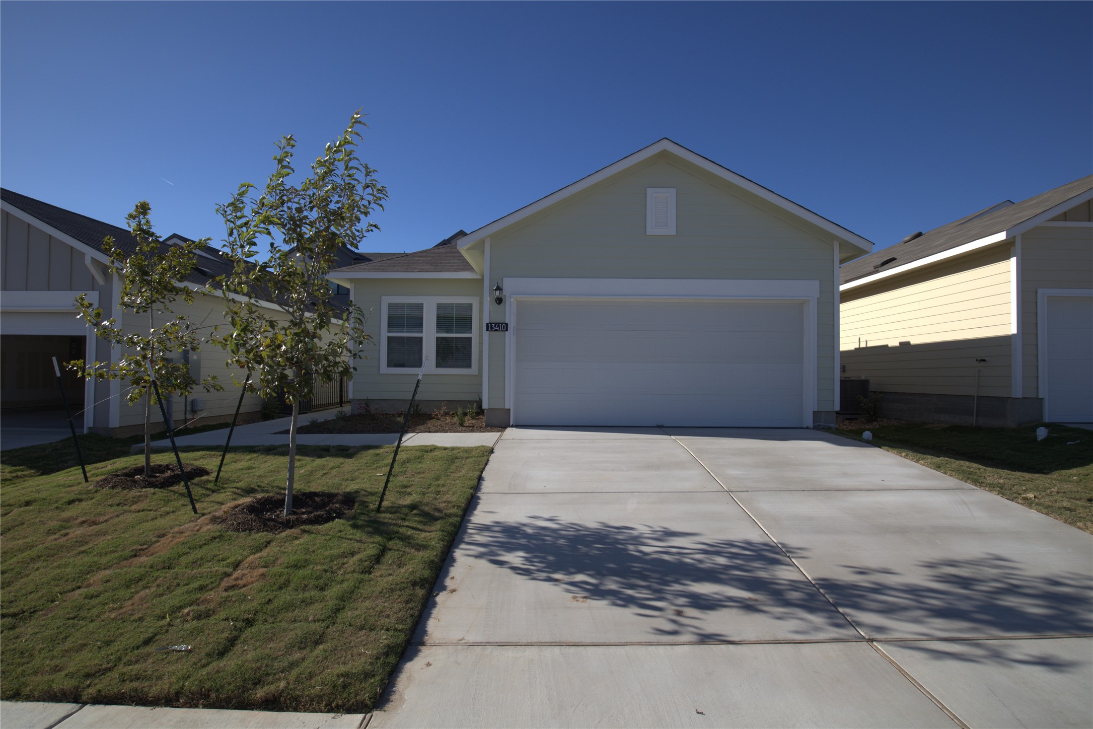 Ranch-style home featuring driveway, a front lawn, and a garage