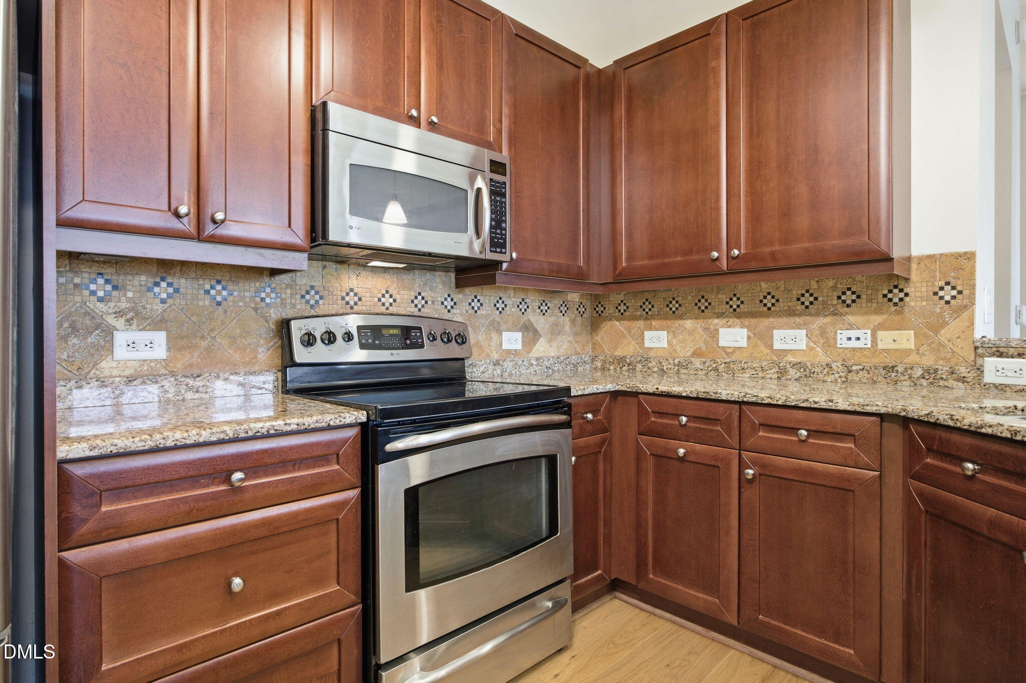 618 North Boylan Avenue, Unit 800 Raleigh, NC 27603 - Photo 5 of 25 a kitchen with granite countertop wooden cabinets and stainless steel appliances