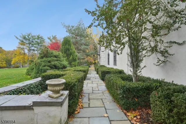 a view of a pathway with a fountain in front of a house