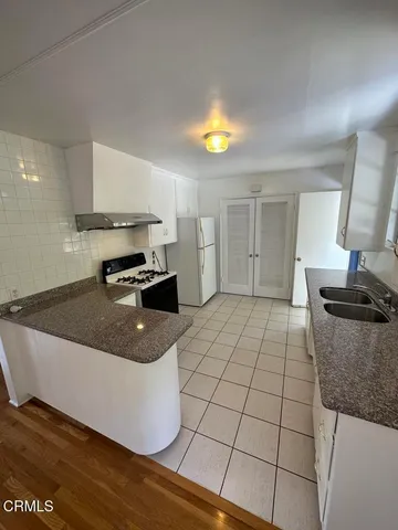 a kitchen with a sink a stove and cabinets