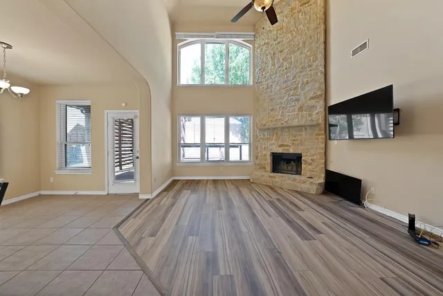 wooden floor fireplace and windows in an empty room