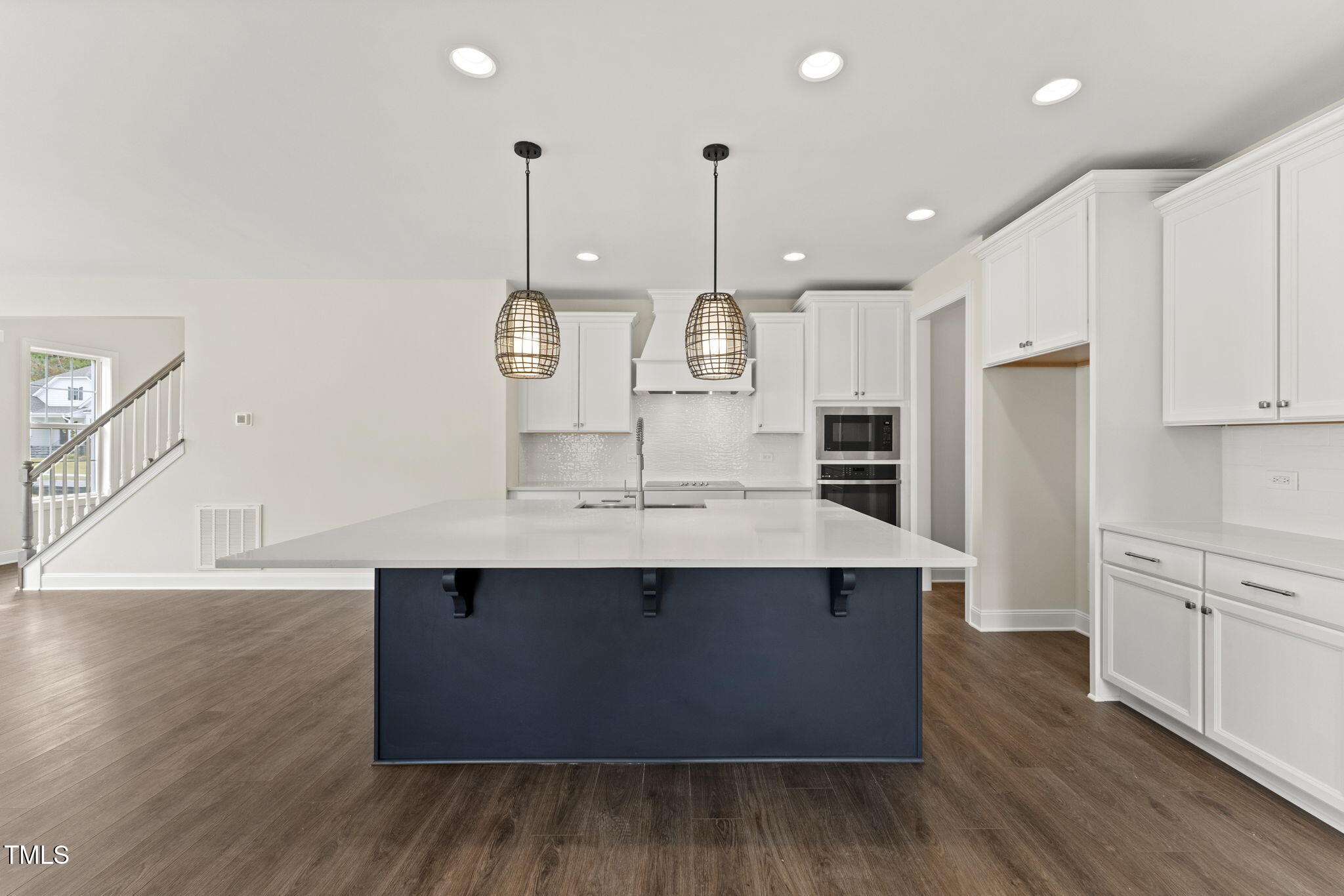 134 Ivy Rdg Road Chapel Hill, NC 27516 - Photo 8 of 37 a large kitchen with stainless steel appliances a large counter top a sink a refrigerator and a wooden floor
