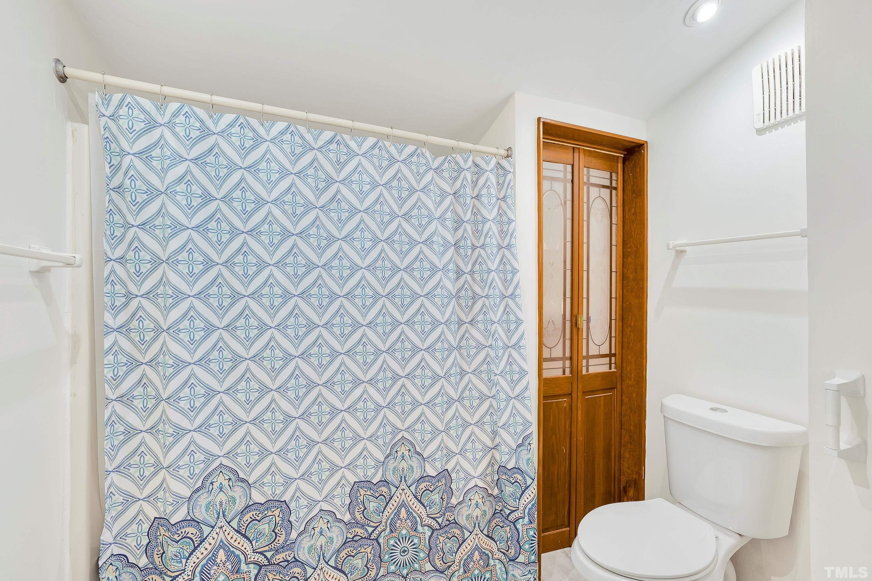 6301 Poole Road Raleigh, NC 27610 - Photo 16 of 20 a bathroom with a toilet and a shower curtain