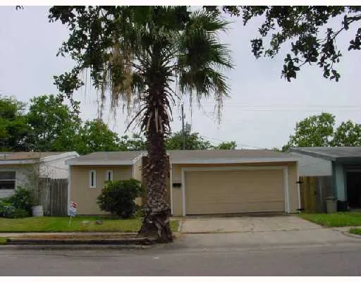 front view of house with a yard and palm trees