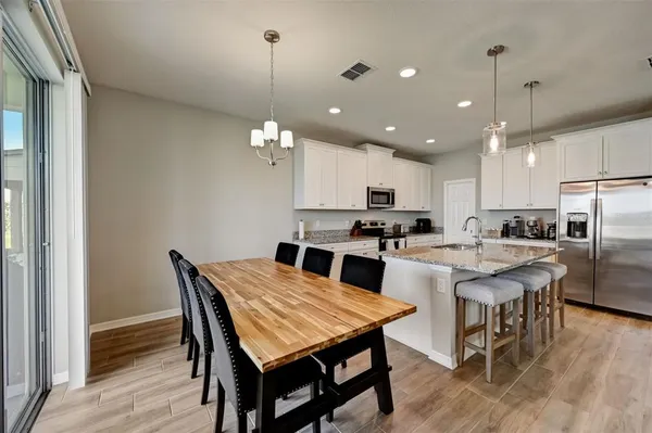 a large kitchen with a table and chairs