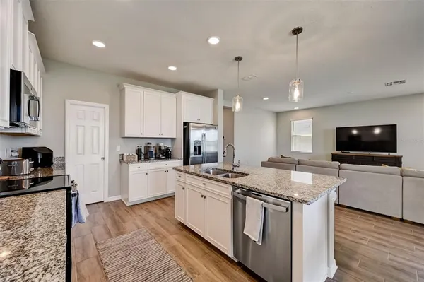 a kitchen that has a lot of cabinets and stainless steel appliances