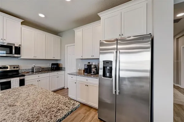 a kitchen with a refrigerator sink and cabinets