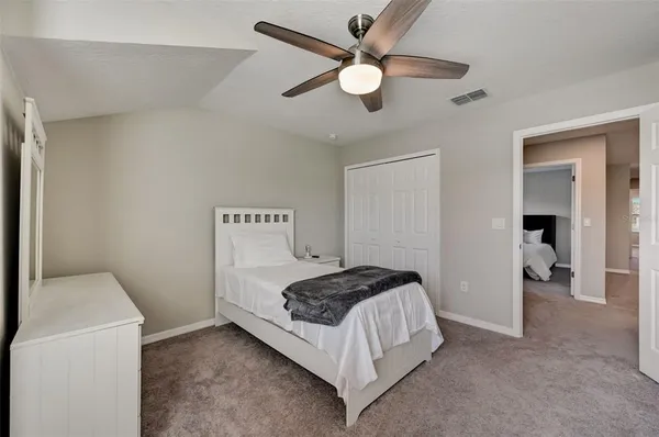 a bedroom with a bed and a ceiling fan
