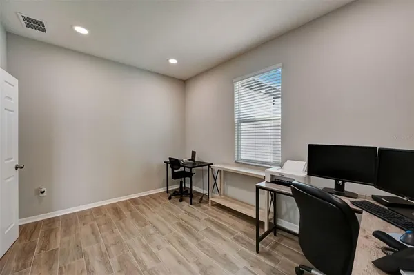 a view of a workspace with furniture and a window