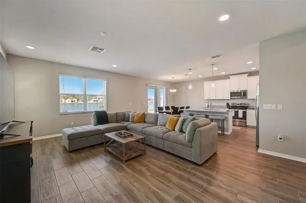 a living room with furniture and a wooden floor