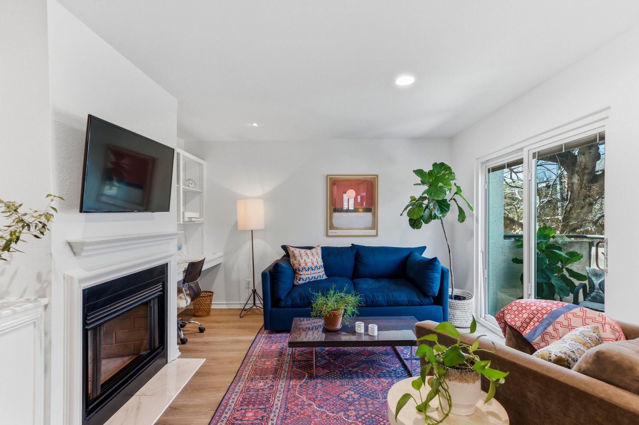 2605 Enfield Road, Unit 218 Austin, TX 78703 - Photo 3 of 26 a living room with furniture a flat screen tv and a fireplace