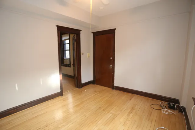 an empty room with closet and a hallway