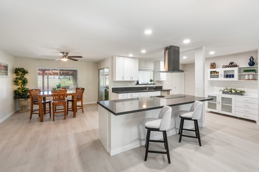 a kitchen with stainless steel appliances granite countertop table chairs sink and cabinets