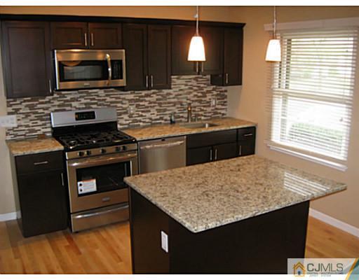 13 Glen Gary Road Middlesex, NJ 08846 - Photo 8 of 23 a kitchen with stainless steel appliances kitchen island granite countertop a stove sink and microwave