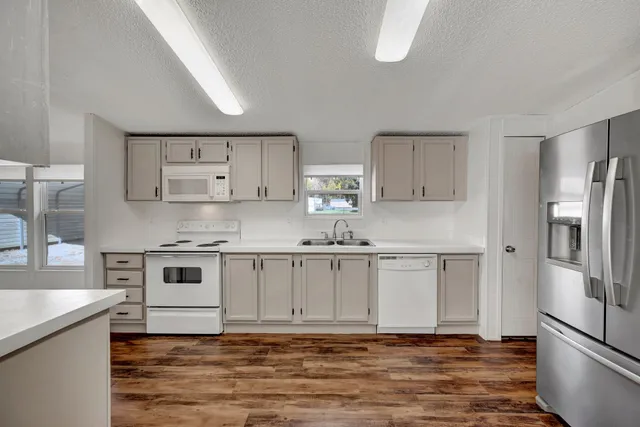 a kitchen with a sink and wooden floor