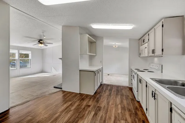 a kitchen with a sink dishwasher a stove and a refrigerator with wooden floor