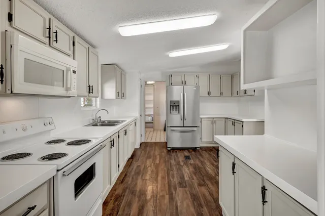 an empty room with windows and ceiling fan