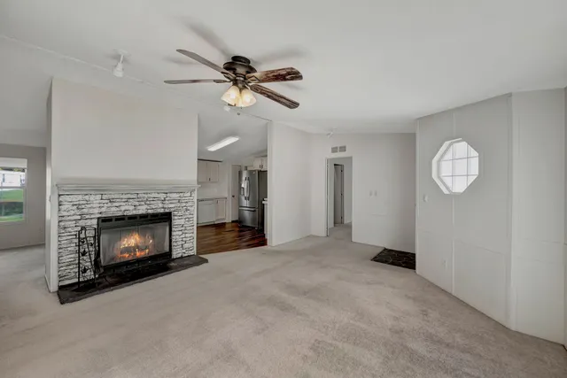 a living room with stainless steel appliances a fireplace and cabinets