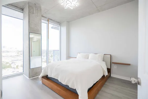 a large bed sitting in a bedroom next to a window