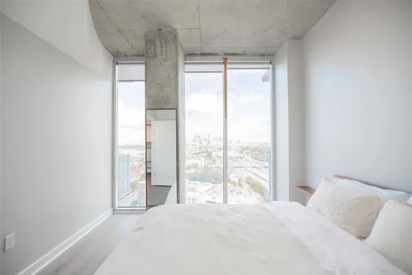 a bedroom with a bed and a large window