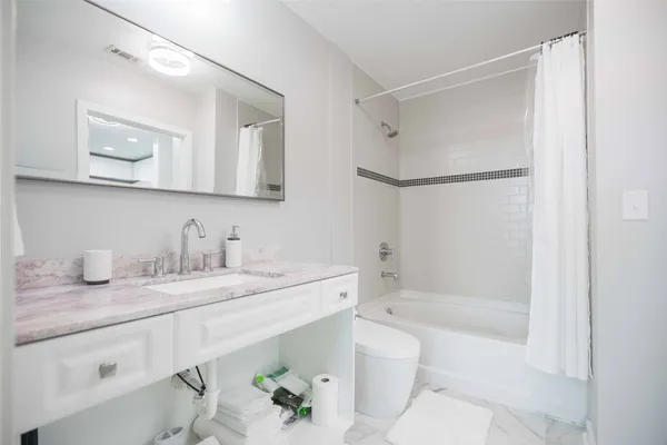 a bathroom with a granite countertop sink mirror toilet and bathtub