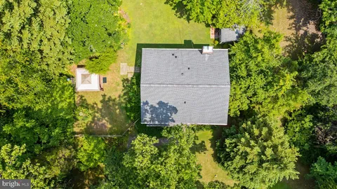 a white building with a big yard and large trees