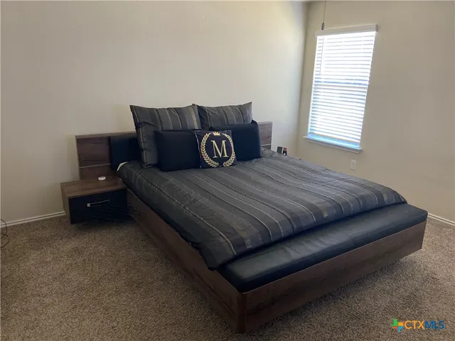 a bed sitting in a bedroom next to a window