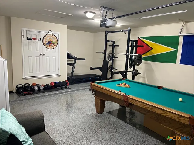 a room with pool table and windows