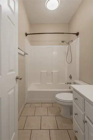 a bathroom with a granite countertop sink a toilet and shower