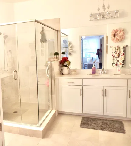 a bathroom with a granite countertop shower a mirror and vanity
