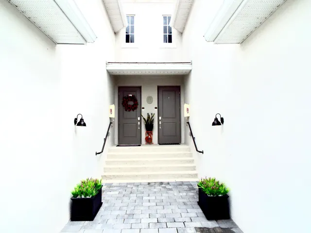 a view of staircase with lots of frames on wall and a large window
