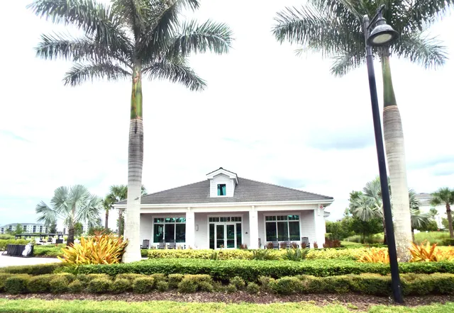 a front view of house with yard and ocean