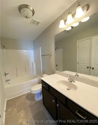 a bathroom with a sink a toilet a mirror a bathtub and vanity