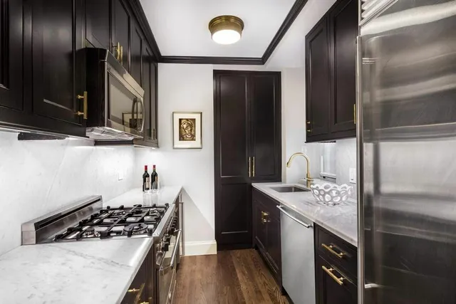 a kitchen with stainless steel appliances granite countertop a stove a sink and a refrigerator