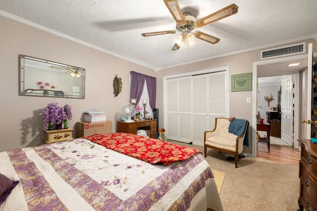 a bed room with a bed a couch and a chandelier