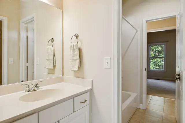 an empty room with a ceiling fan and carpet