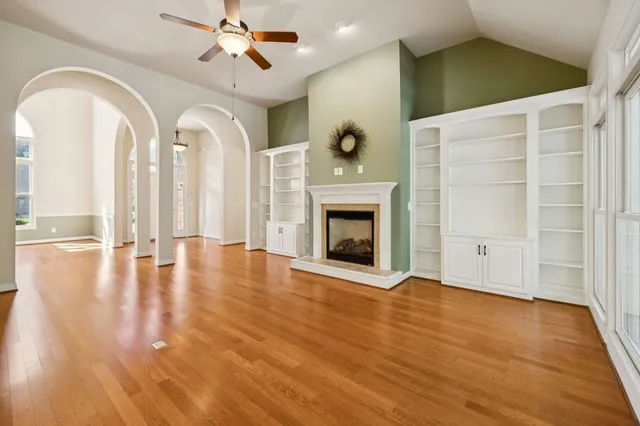 wooden floor fireplace and windows in an empty room