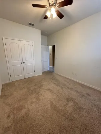 an empty room with chandelier fan