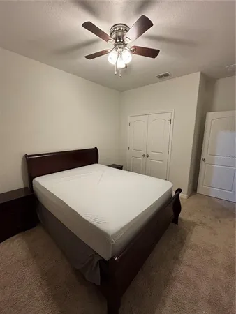 a bed sitting in a bedroom and chandelier fan