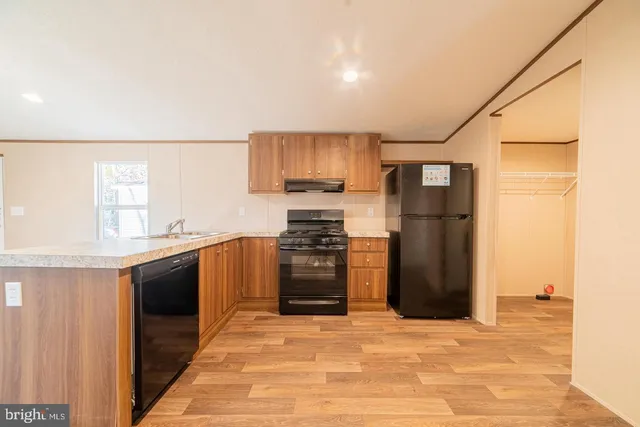 a kitchen with granite countertop a refrigerator and a stove top oven